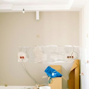 An indoor scene showing a messy home renovation project with tools, paint, and materials scattered around.